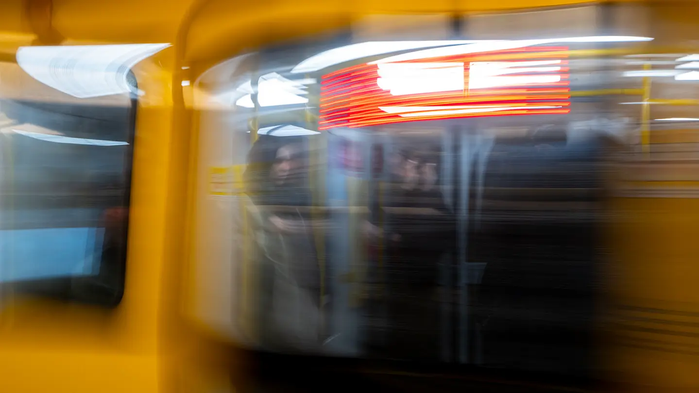 Motion-blurred subway train arriving at an underground station.