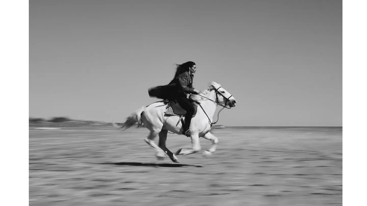 Une femme au galop dans un paysage désertique 