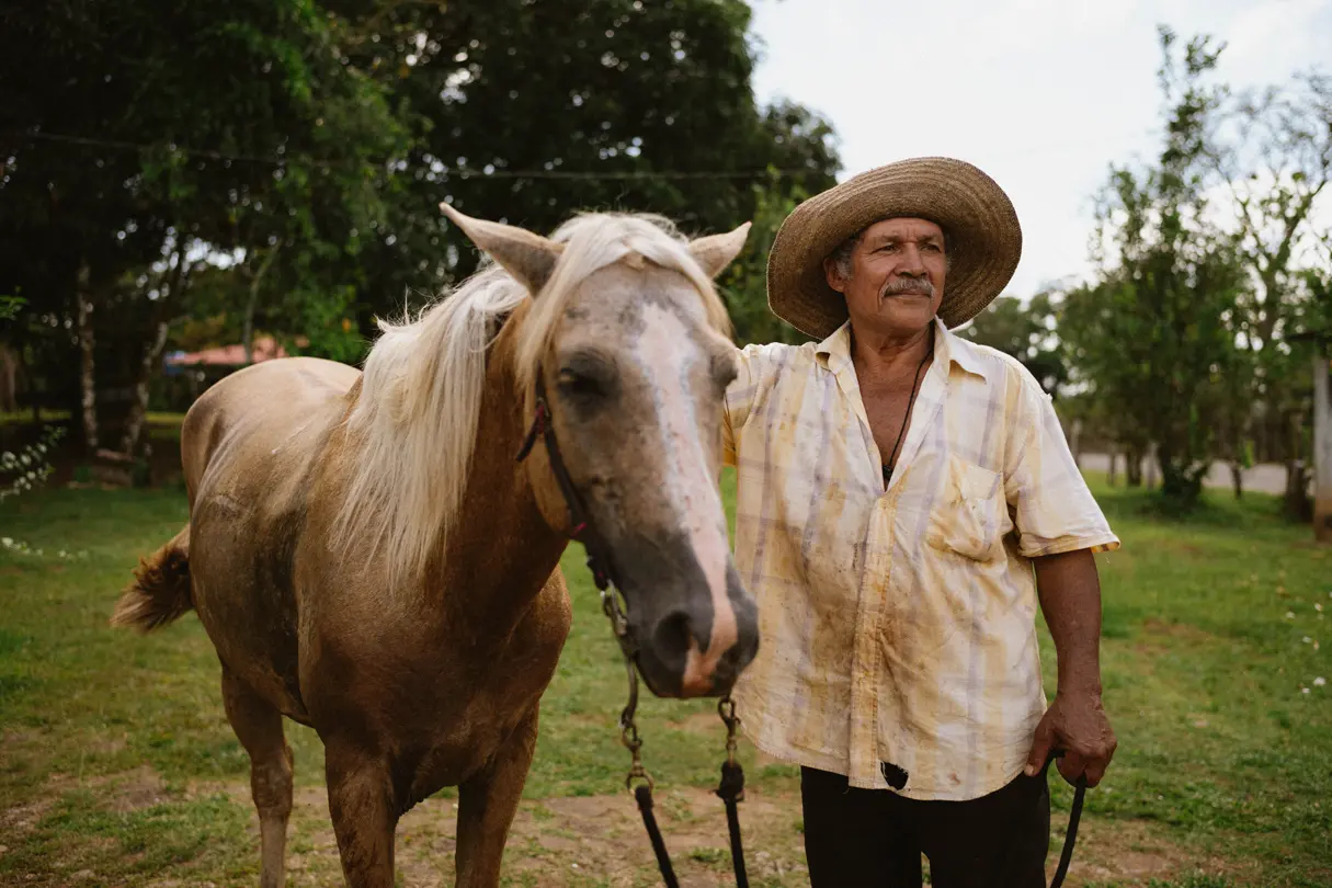 Mann mit Hut steht nebem Pferd in Panama