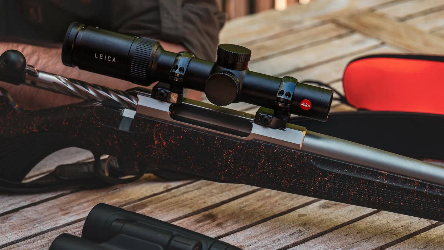 Hunting–Leica–riflescope–resting–on–a–wooden–table