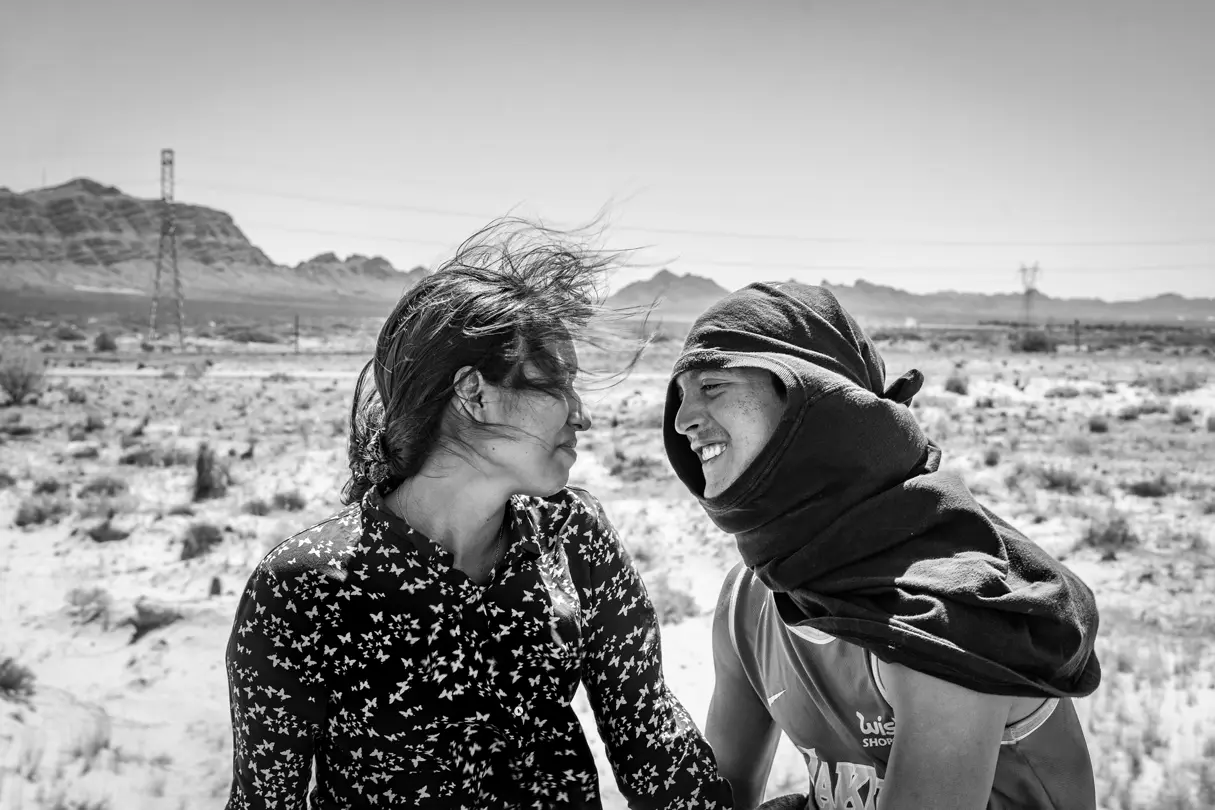 LOBA Winner 2025 image:Black-and-white portrait of two people smiling together in a desert landscape.