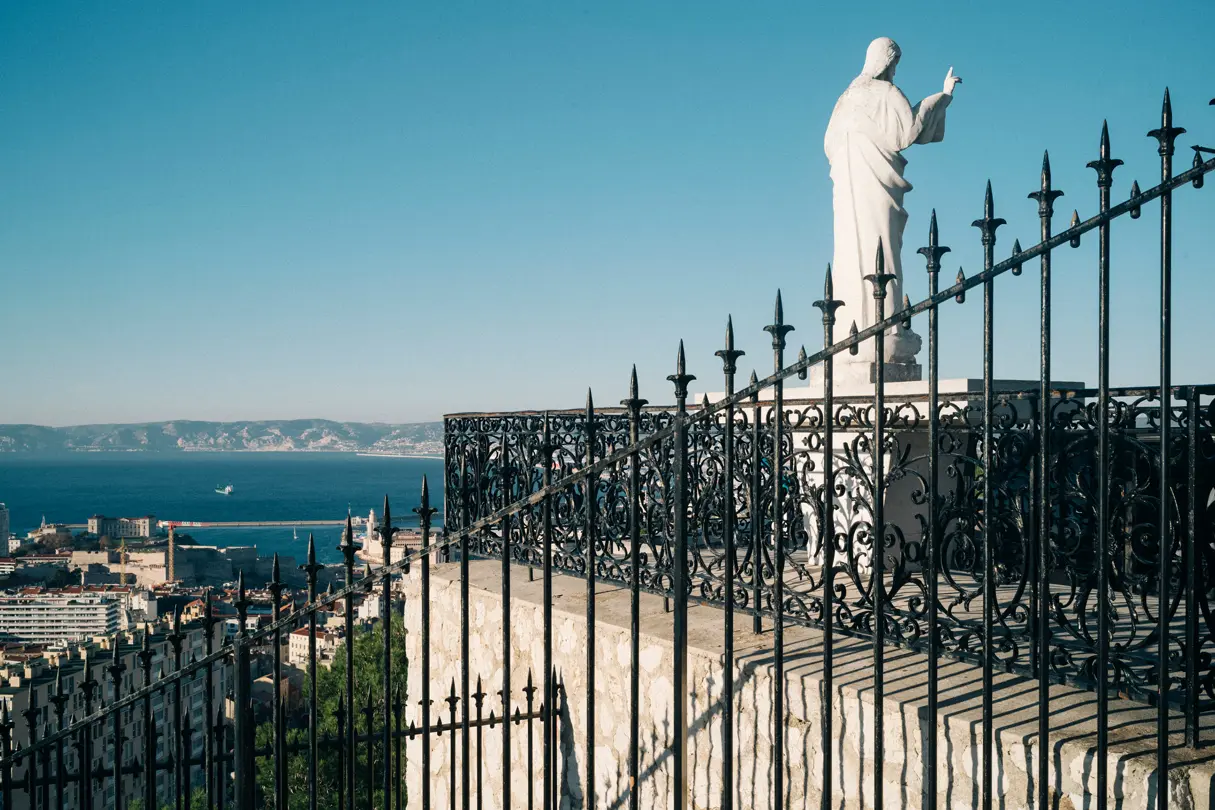 Paysage de Marseille avec une statue surplombant la ville et la mer.