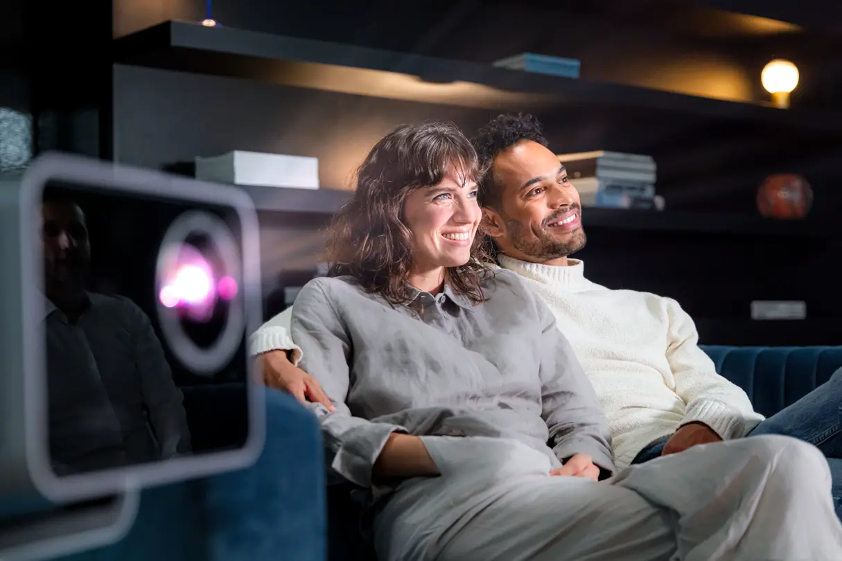 A woman and a man sitting beside a Leica Cine Play 1.
