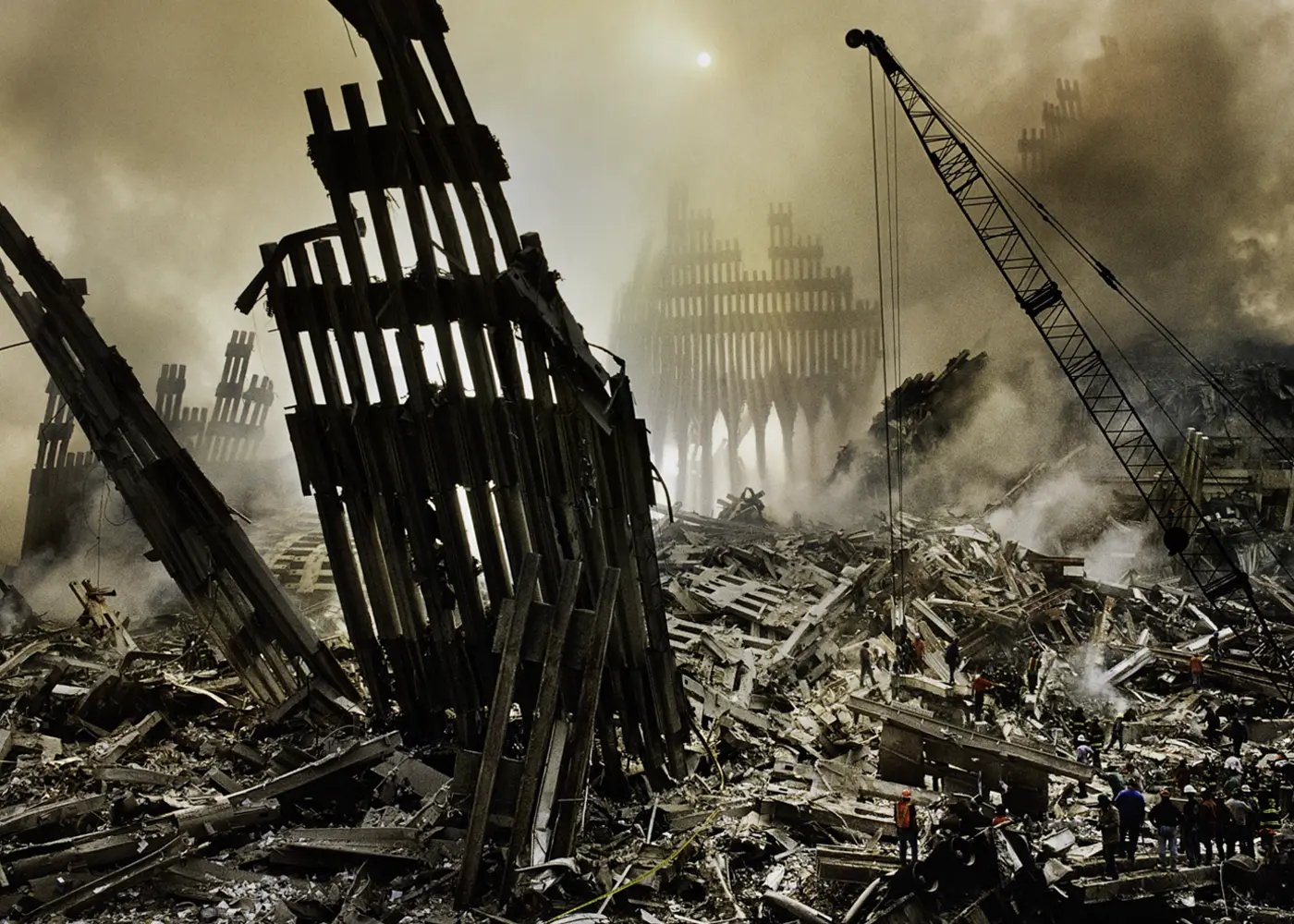 Aftermath of the World Trade Center attacks in New York, with twisted steel structures, smoke, debris and rescue workers at Ground Zero.