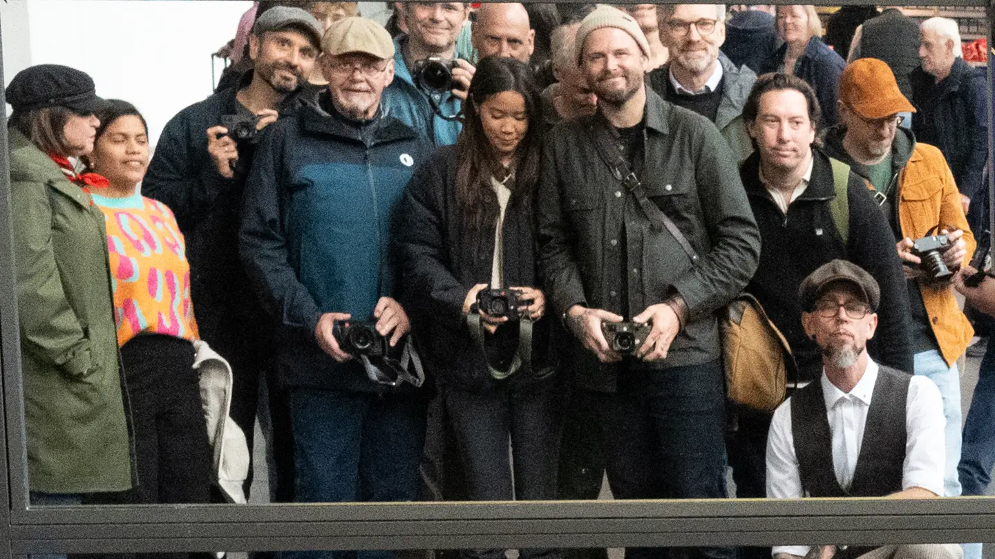 A group of photographers gathers with their cameras for a group portrait.