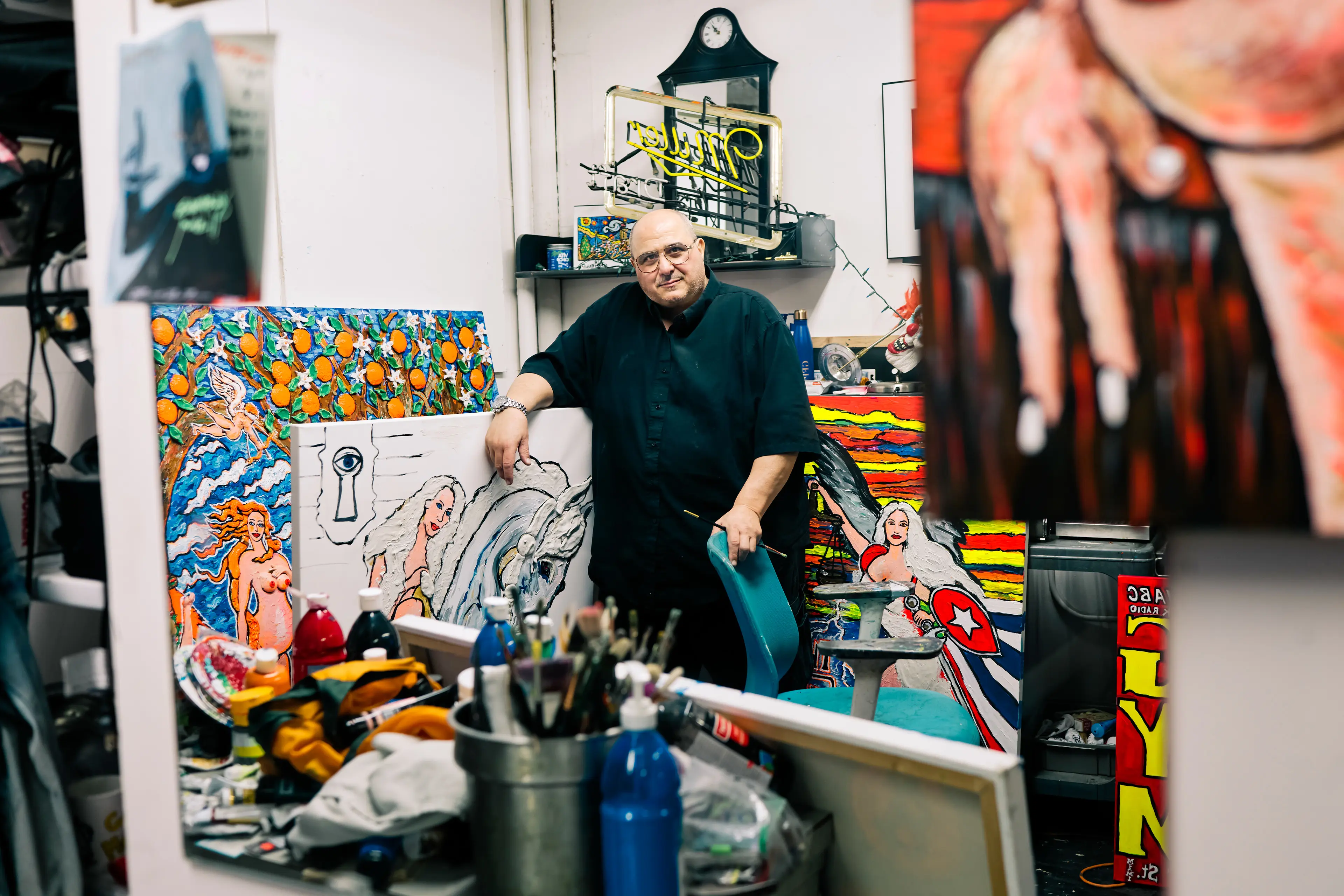 A painter among his paintings and painting supplies