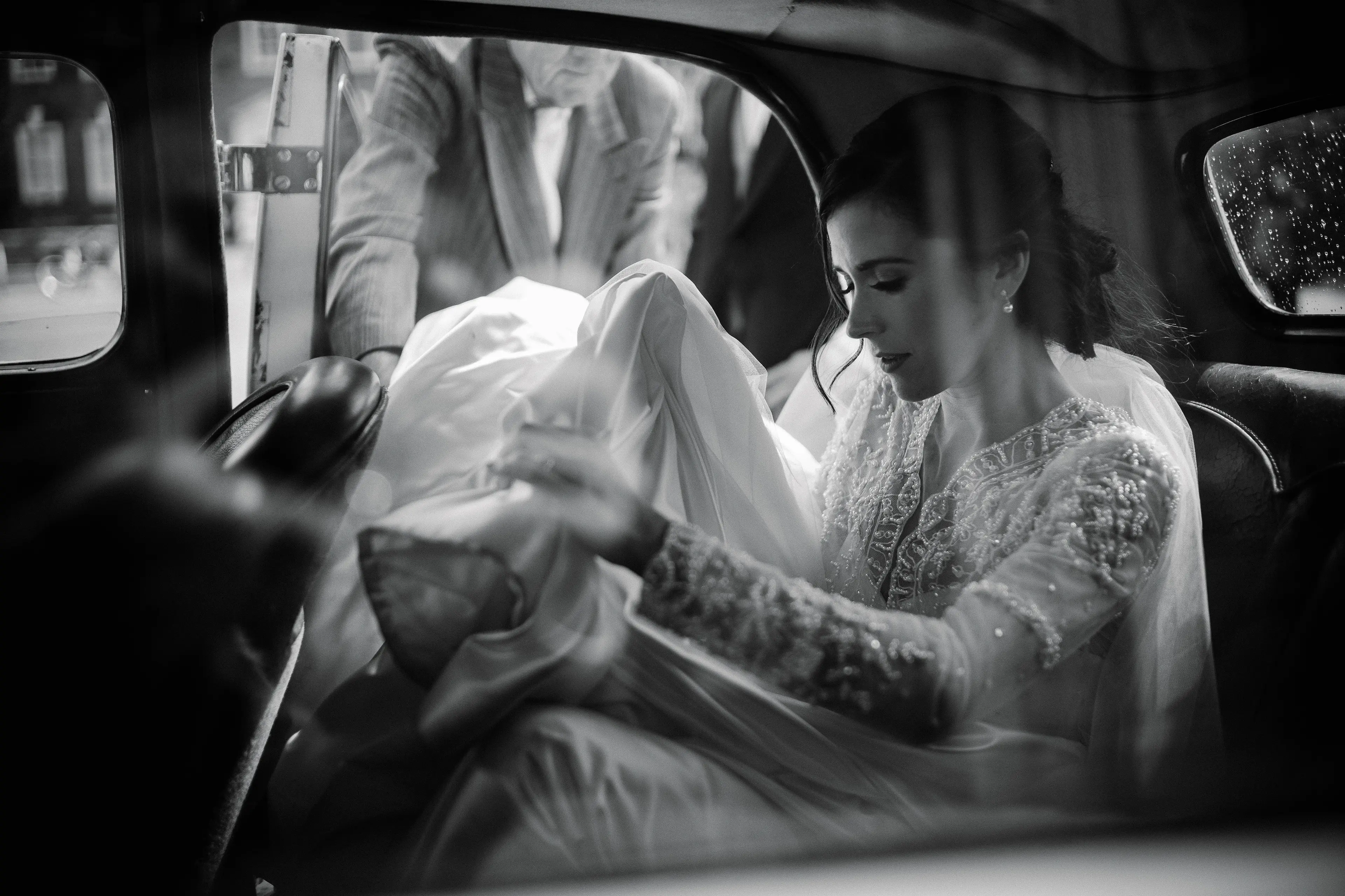 Black and white portrait of a bride in a car