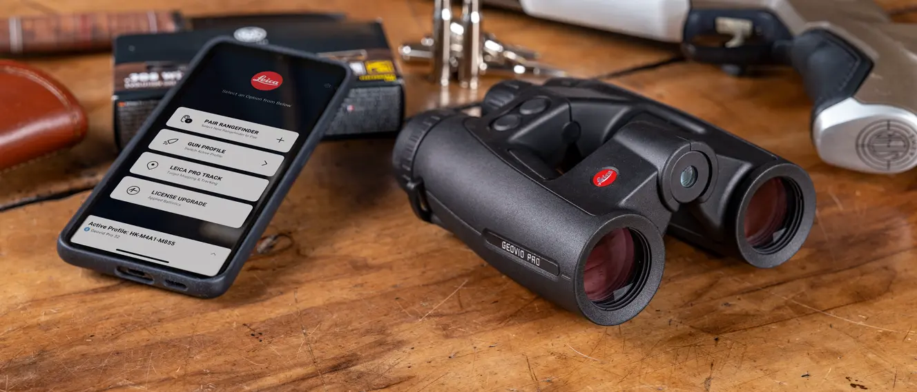 Leica-Geovid-Pro-Hunting-Binoculars-connected-with-a-smartphone-on-a-wooden-table