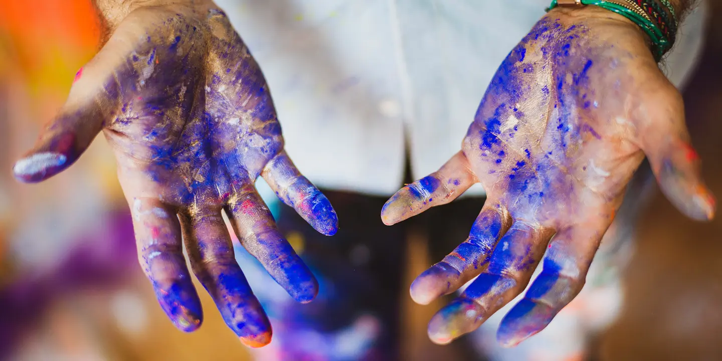 Close-up of hands smeared with blue paint.
