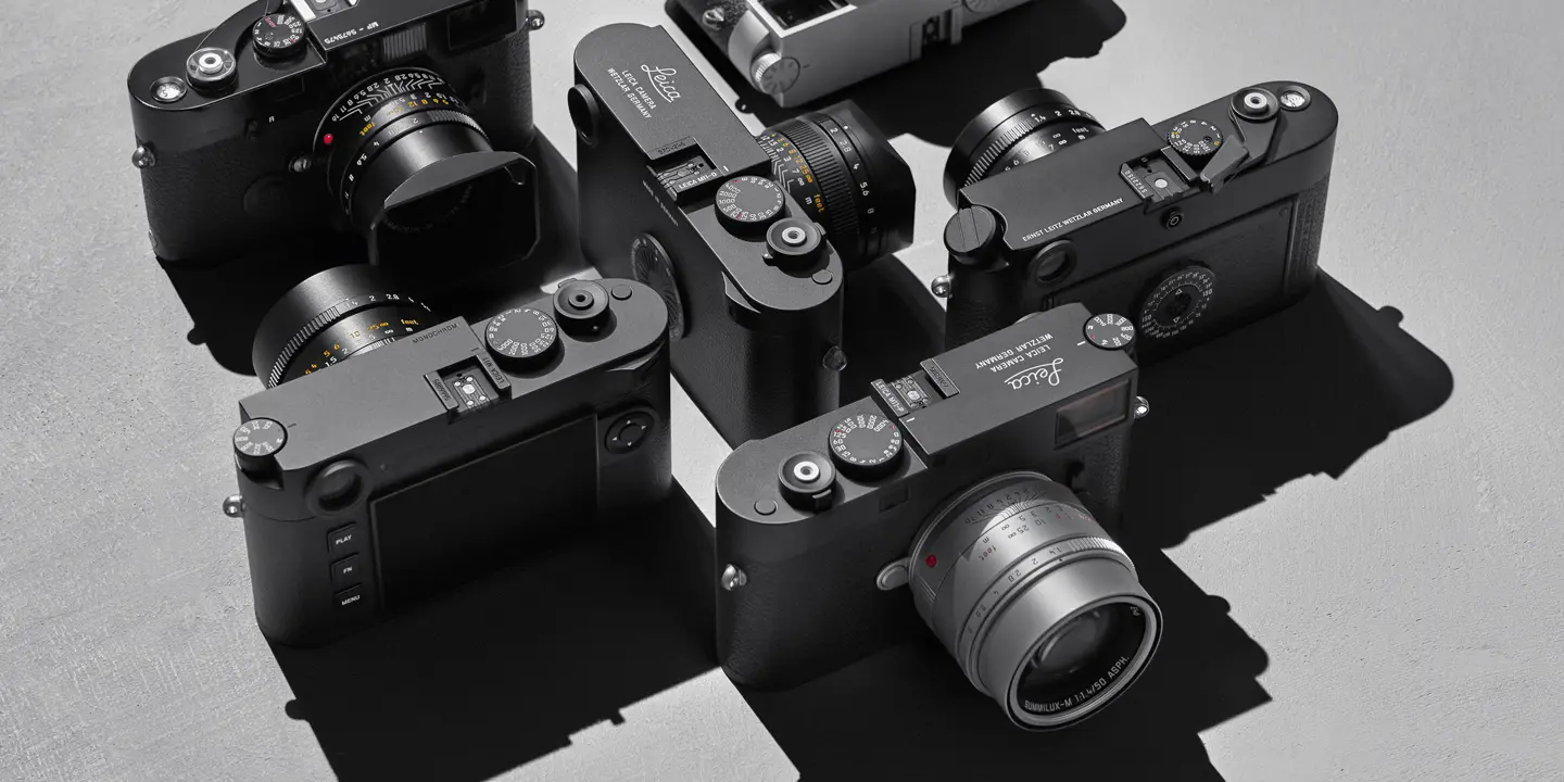 Top view of several Leica cameras on a gray background