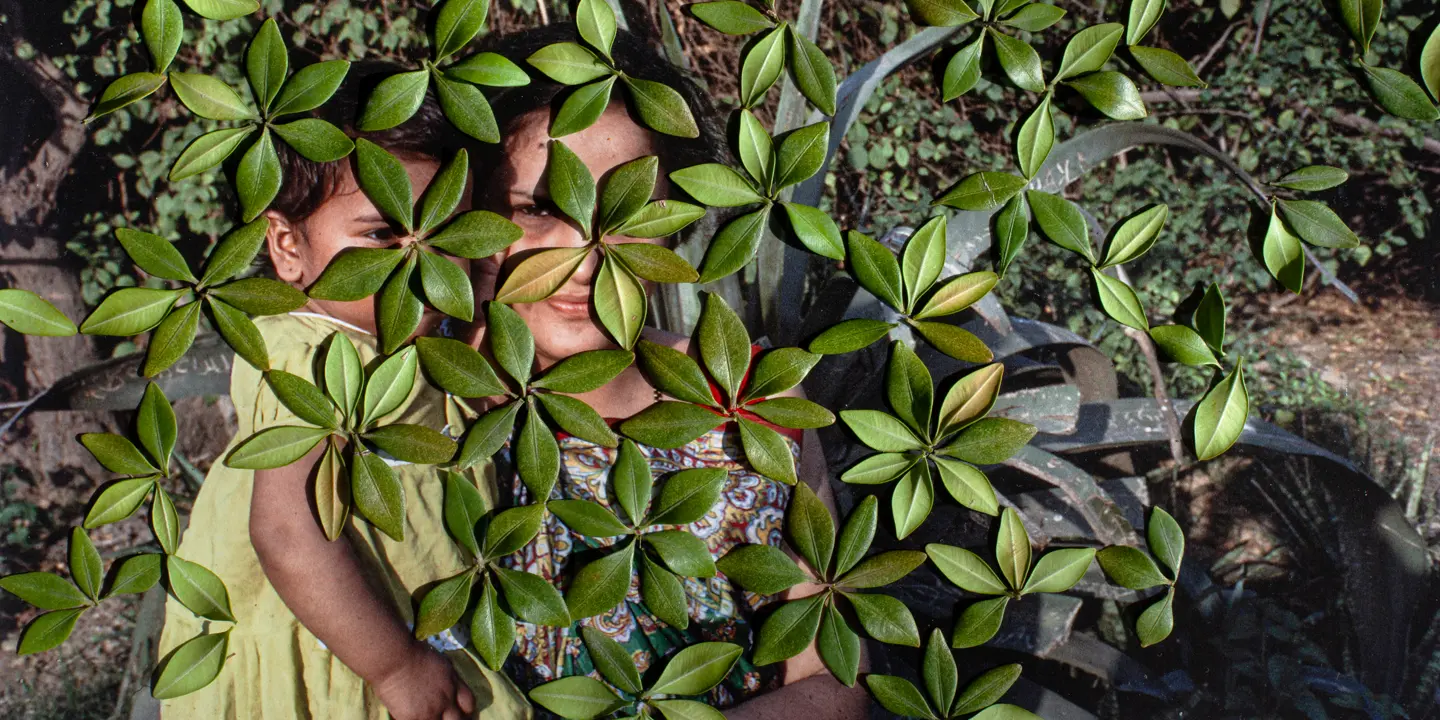 woman with her child behind leafs