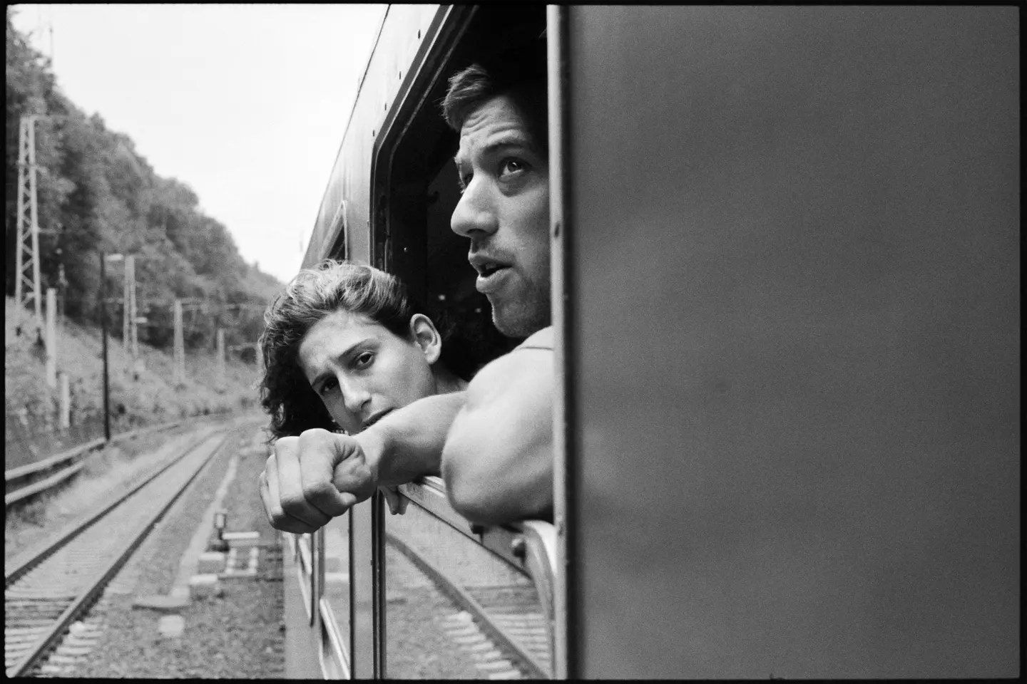 Une femme et un homme dans un train, les visages au vent.