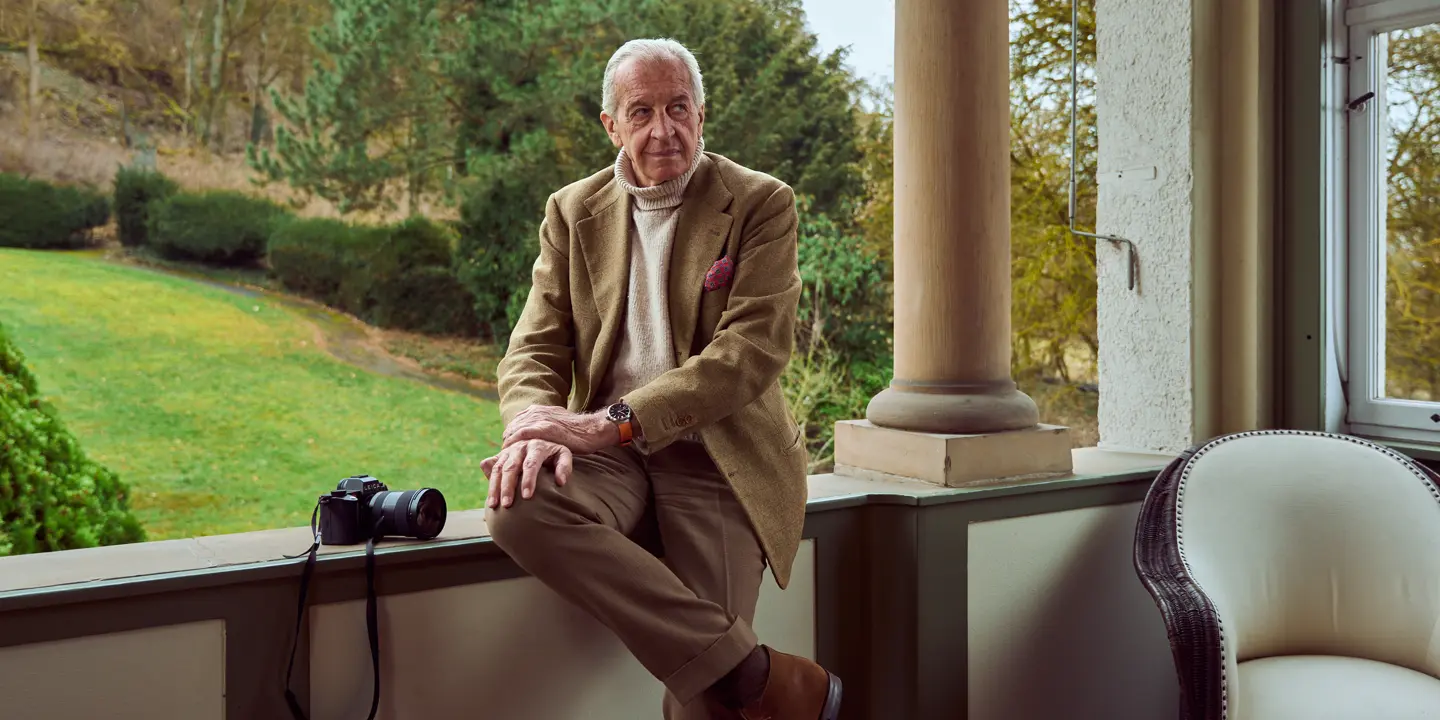 John Golberger is sitting on a veranda with a Leica beside him and a Leica ZM 12 on his wrist