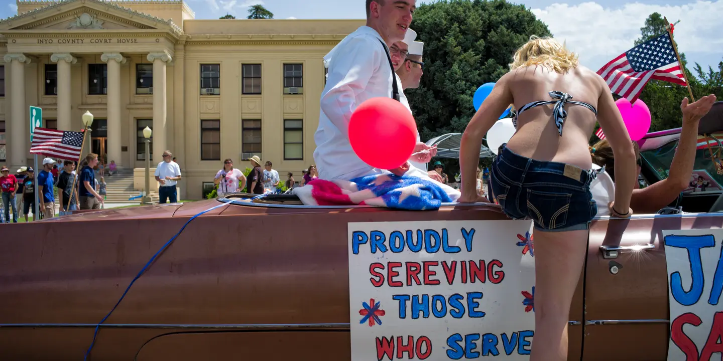 Woman gets into a convertible with sailors in America