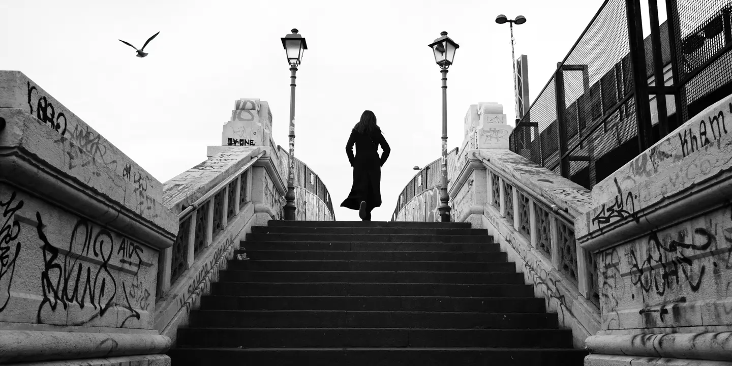 black-and-white photograph, woman running up a flight of stairs