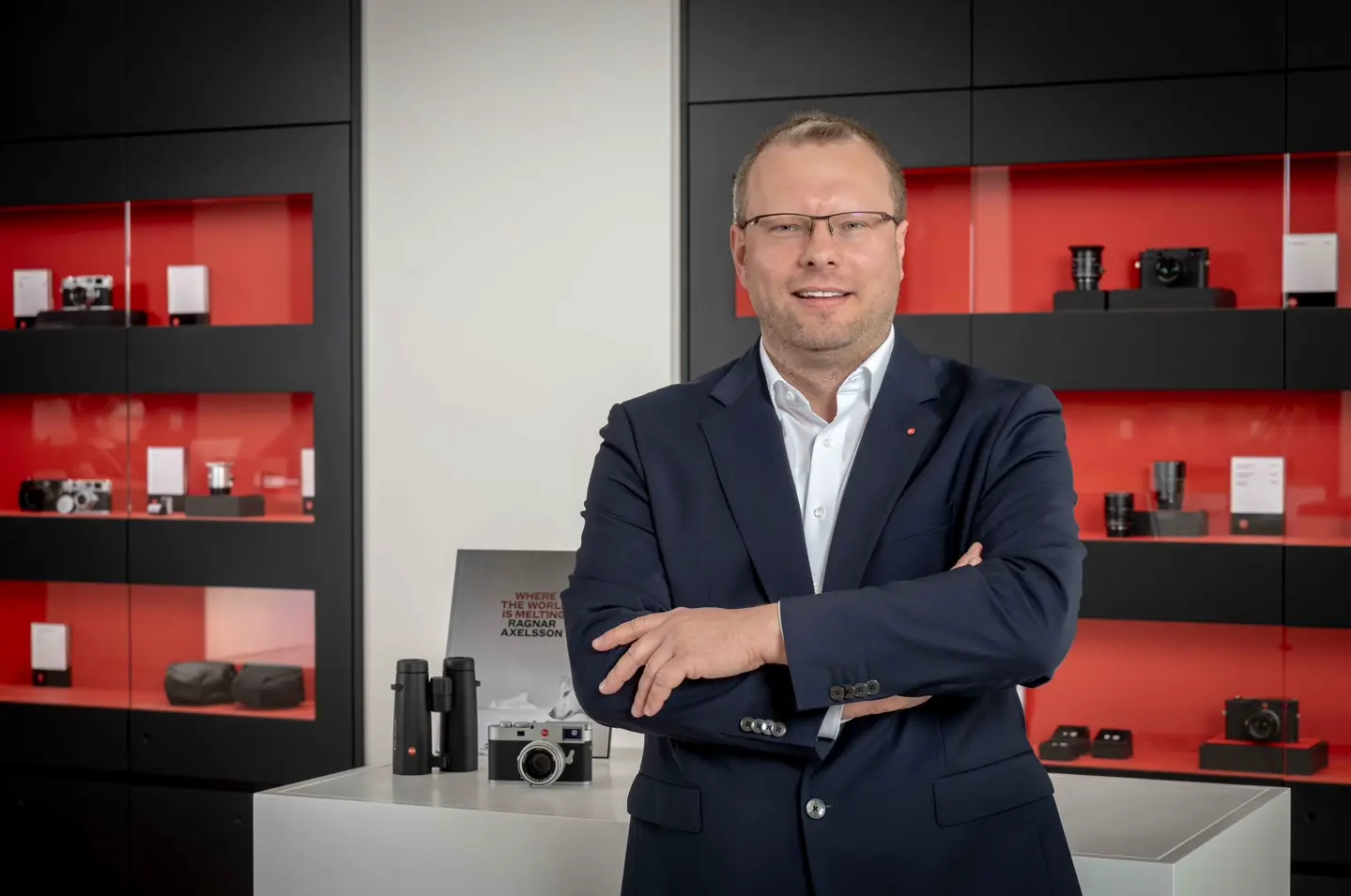Portrait of Dr. Ronny Fritsche in front of a camera display cabinet.
