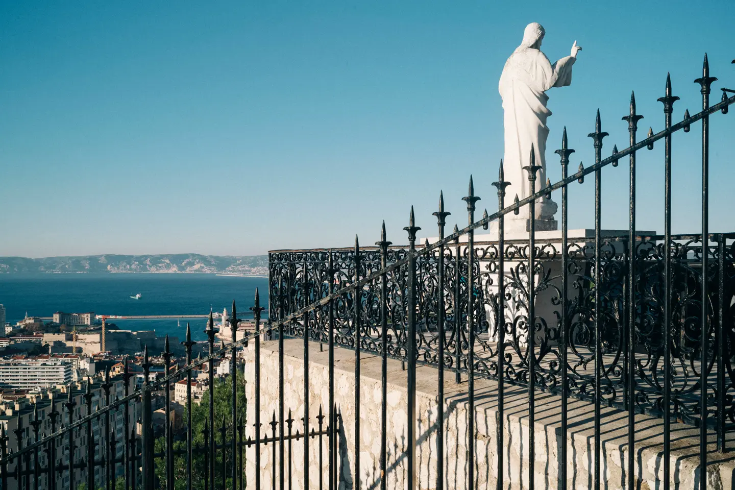  Paysage de Marseille avec une statue surplombant la ville et la mer.