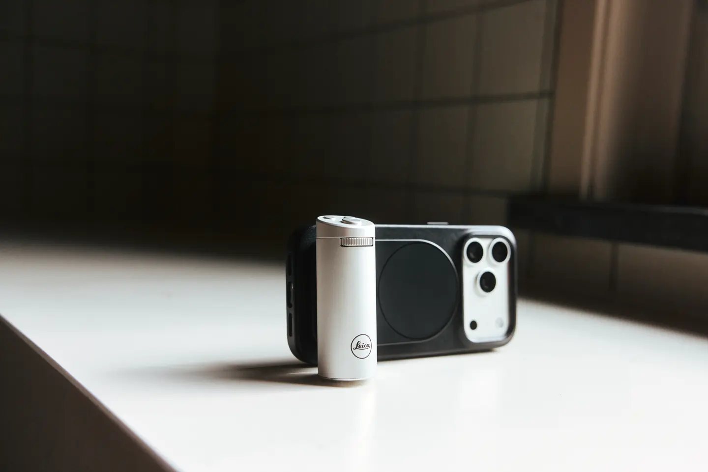 iPhone 18 with black Leica Case Grip on a table.