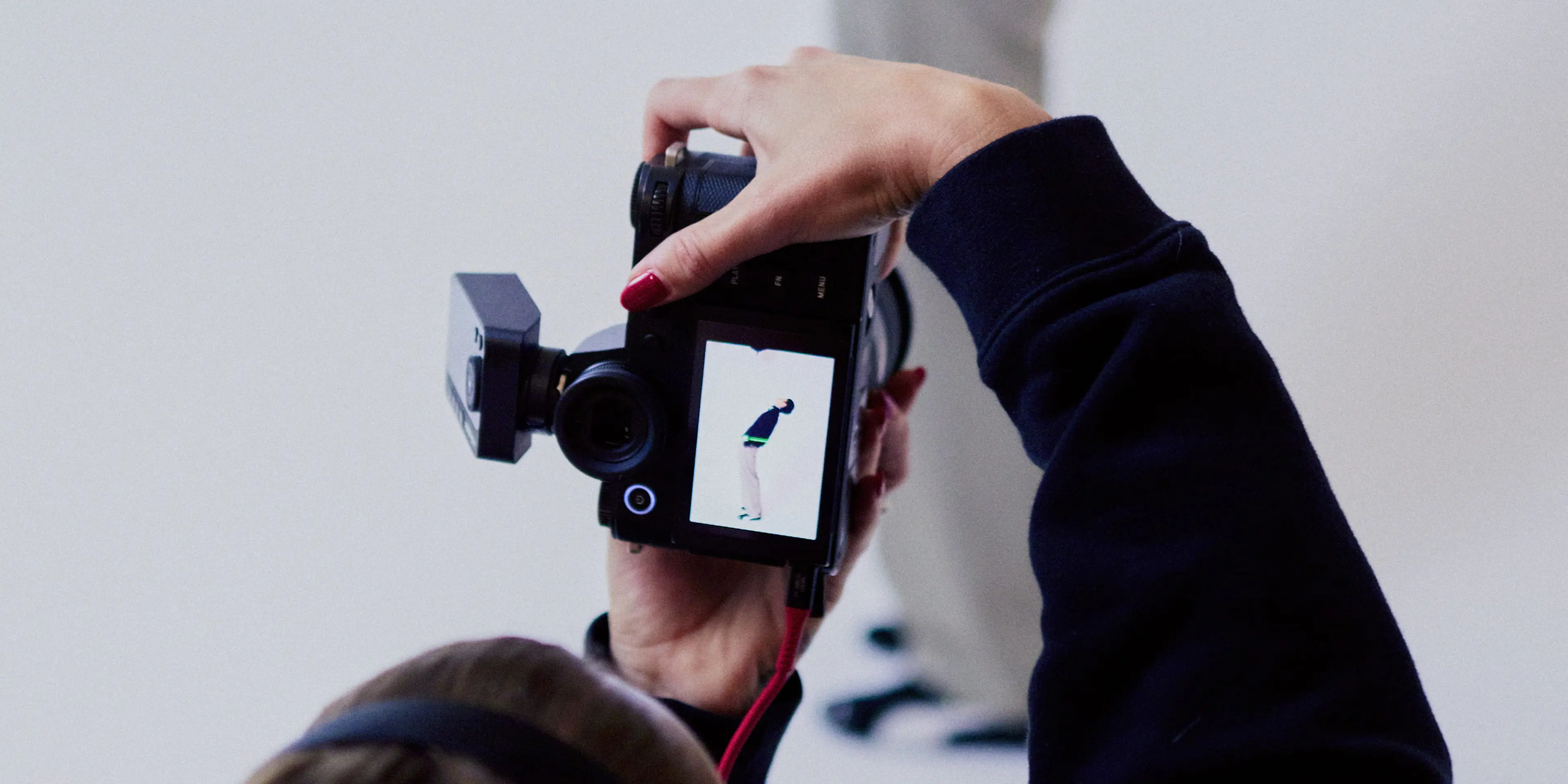 Photographer from behind in a photo studio photographing a man