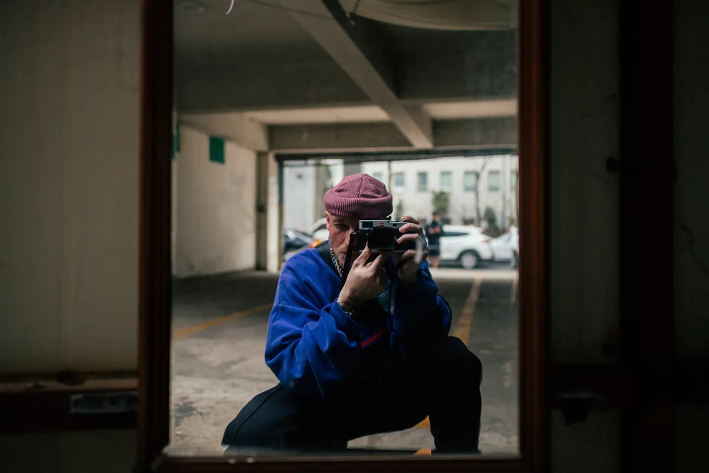 A man takes a picture of himself in a mirror in a garage.