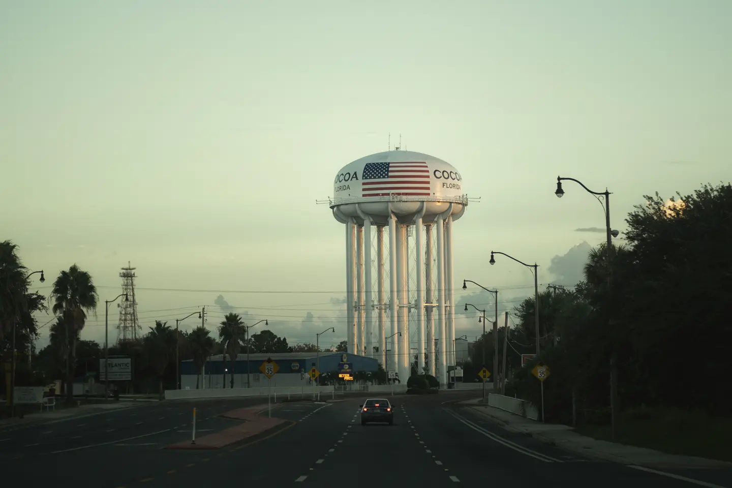 An empty road leads to a water tower labelled ‘Cocoa, Florida’.