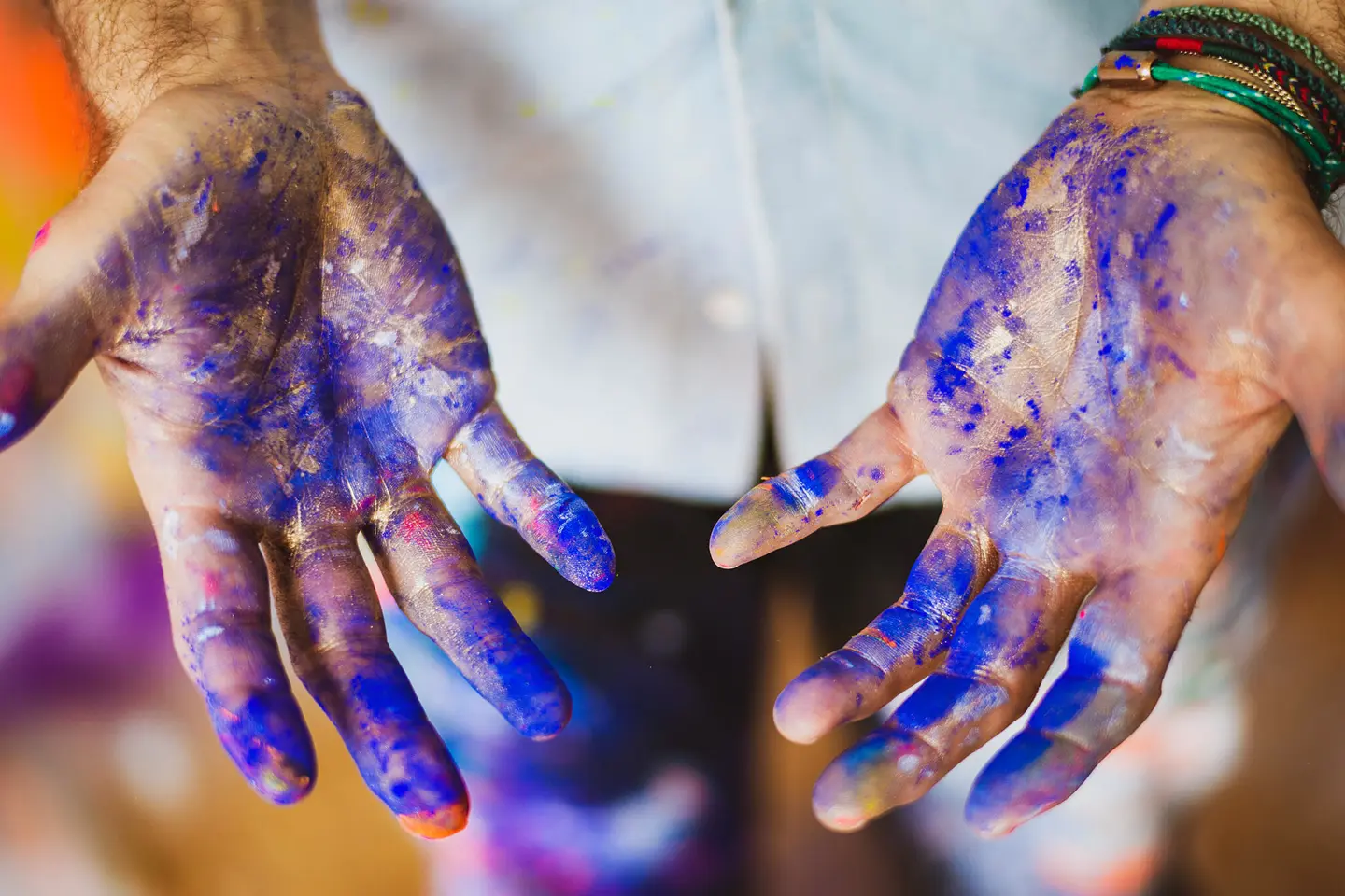 Close-up of hands smeared with blue paint.