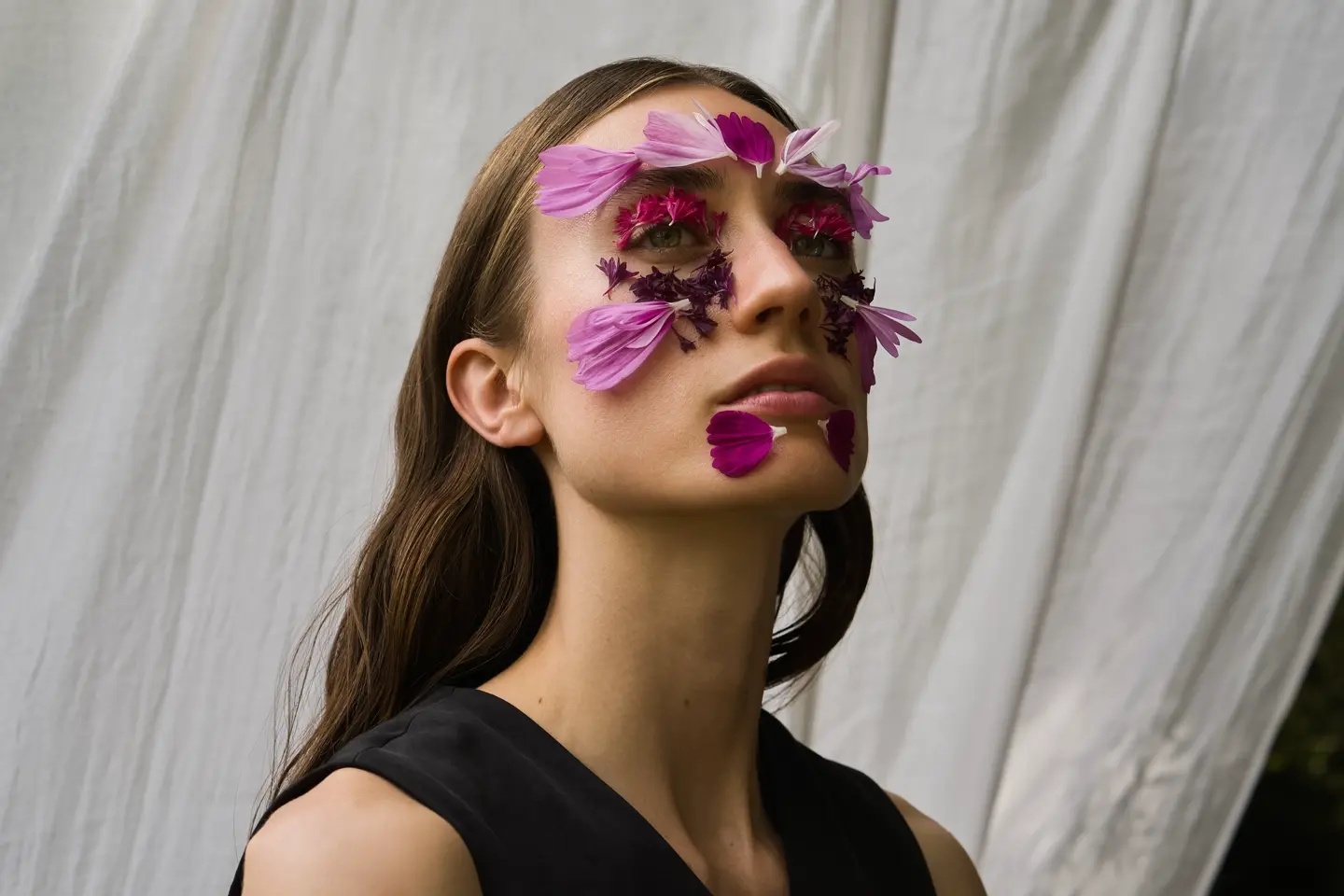 Ein Portrait einer Frau mit Blumen auf ihrem Gesicht.