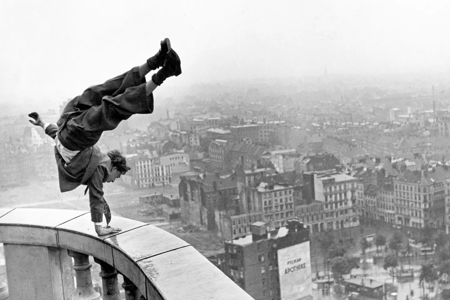 Man doing a handstand on a high banister