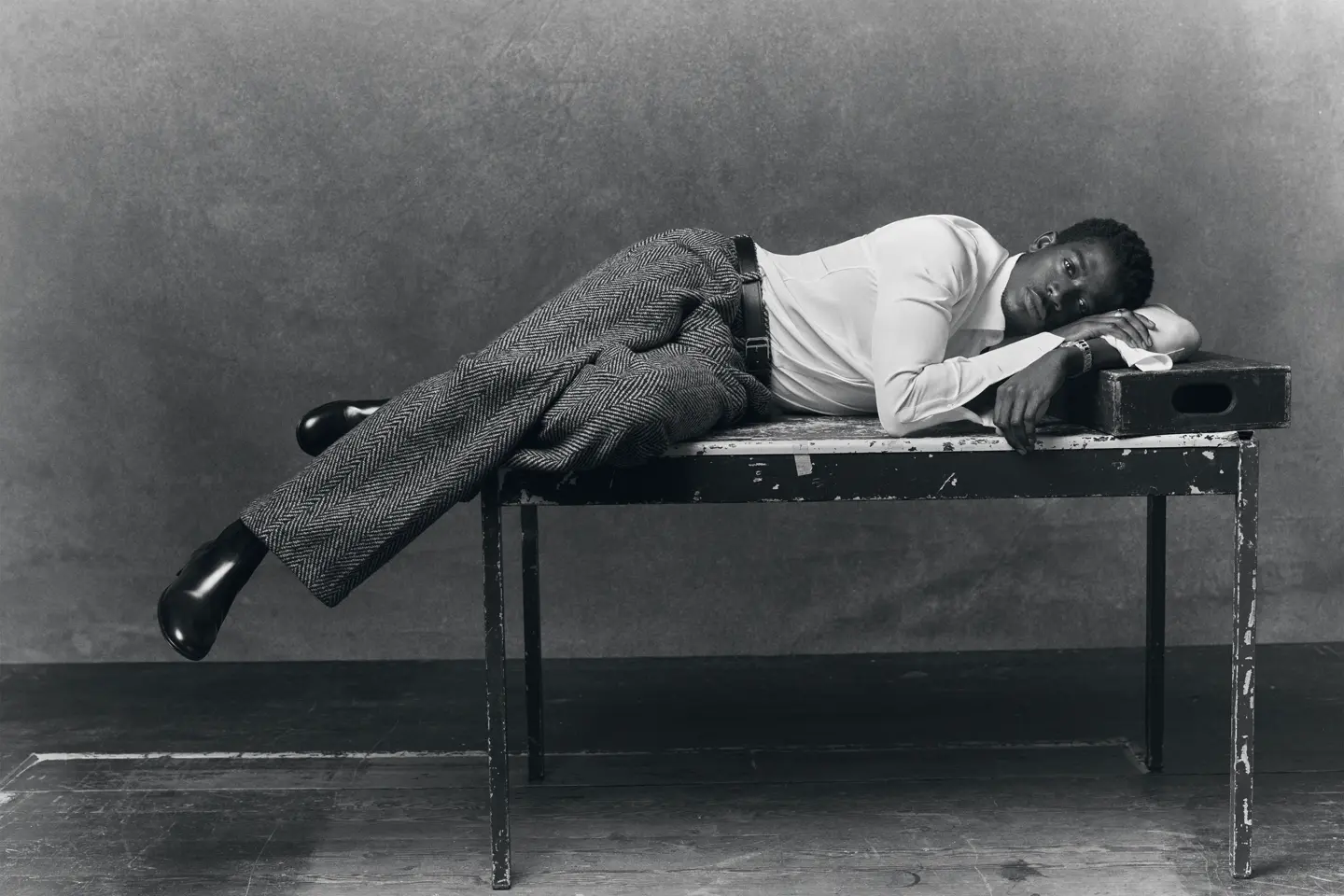Portrait en noir et blanc de l'acteur Damson Idris allongé sur une table