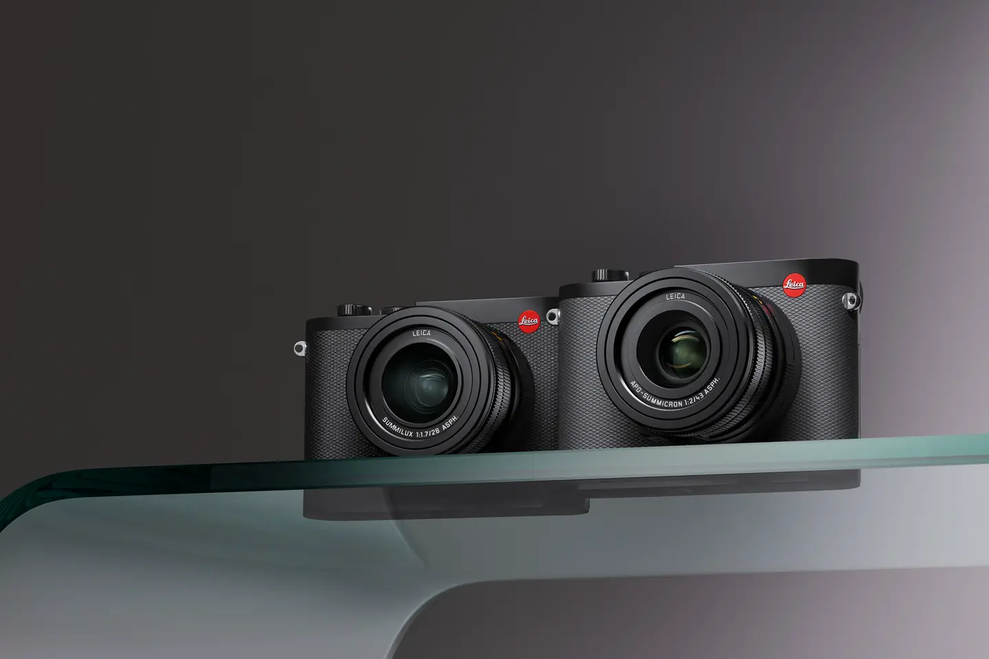 Two compact cameras on a glass table