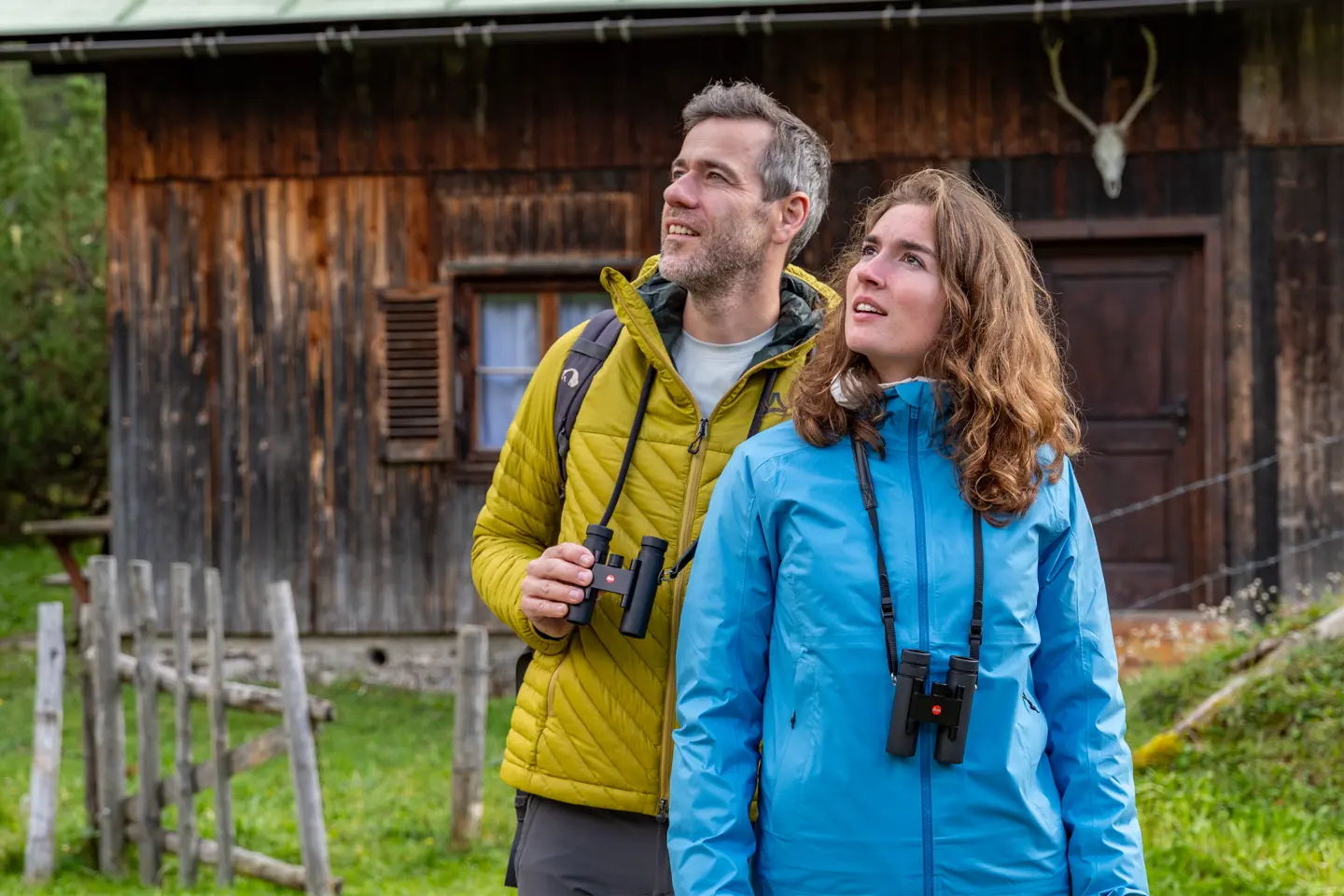 Two hikers in the mountains with their Leica Noctivid Compact