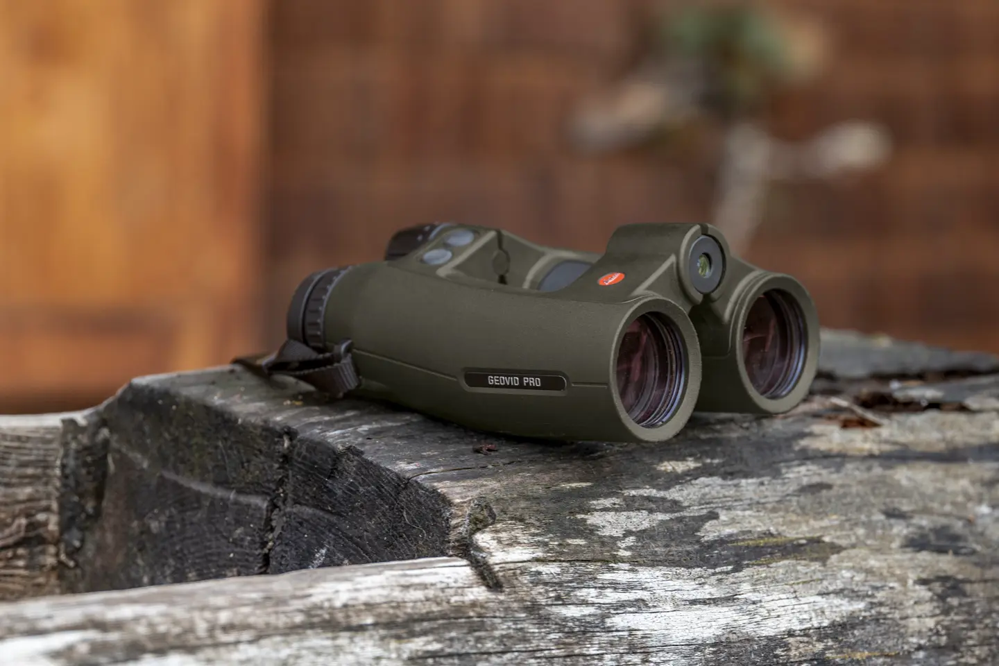 Leica Geovid Pro in olive green is lying on a wooden floor