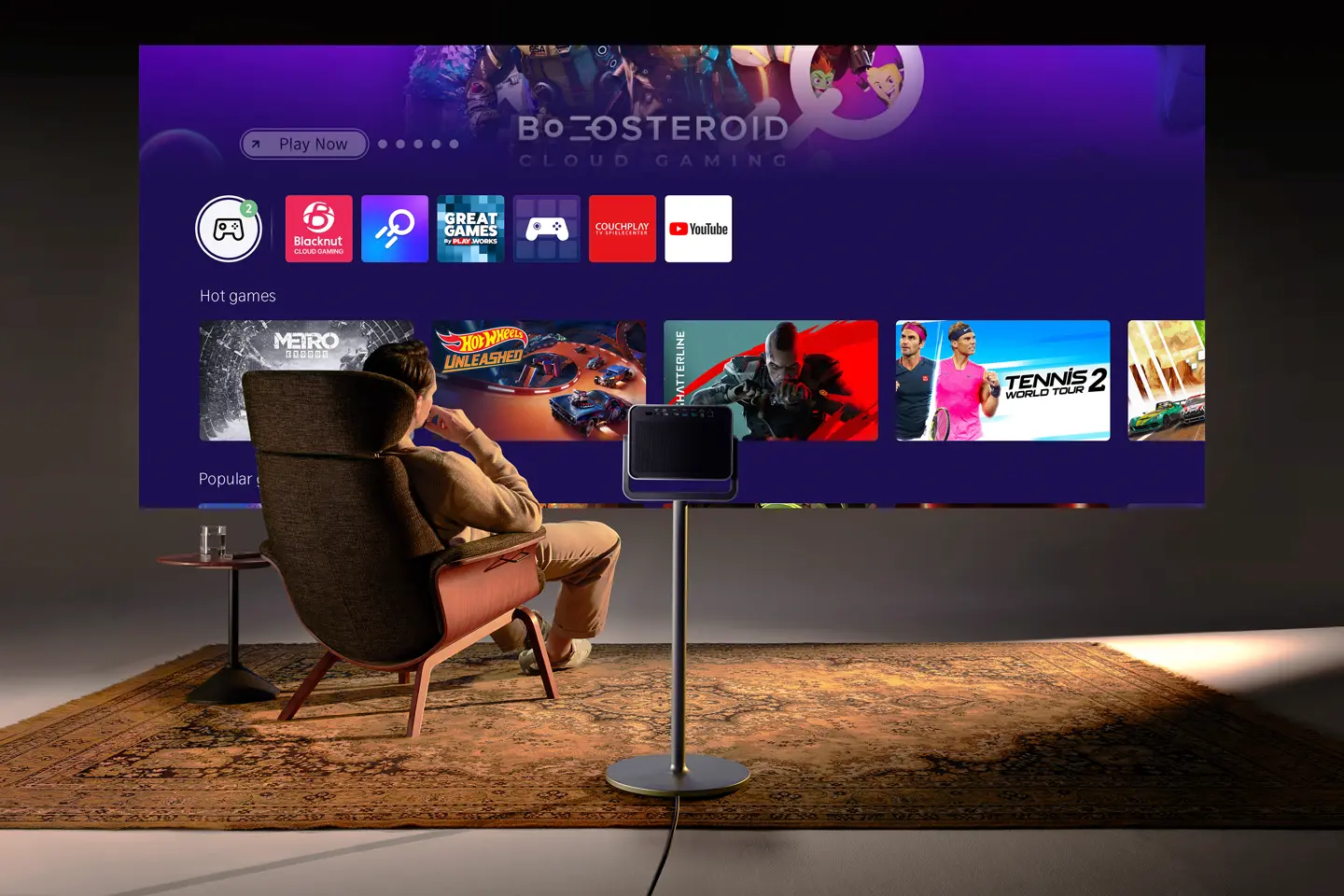 Man sitting in an armchair looking at a screen from Leica Cine Play 1 with the Vidaa