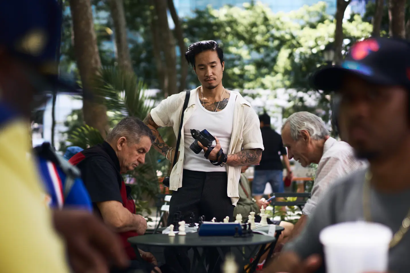 Documentary photograph of photographer Billy Dinh observing a chess game in a New York City park with a Leica Q, capturing everyday street photography and urban life.