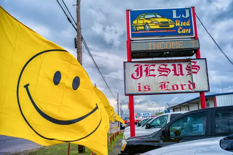 Yellow smiley flag in front of a sign with the inscription 'Jesus is Lord'