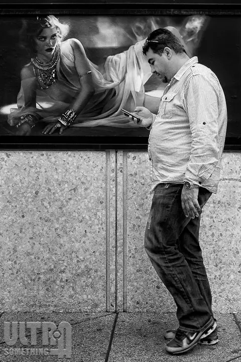 man walking in front of poster B&W 