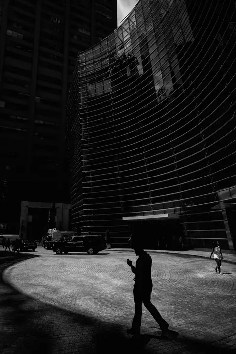 people walking and building b&w