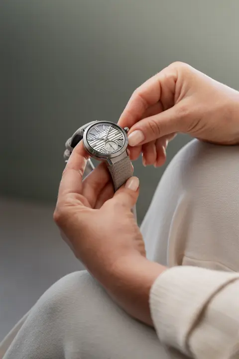 A woman is holding a Leica watch in her hand