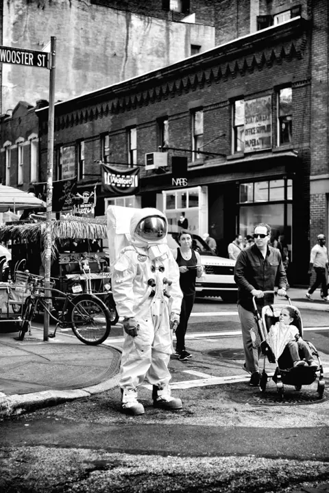 person in astronaut costume b&w