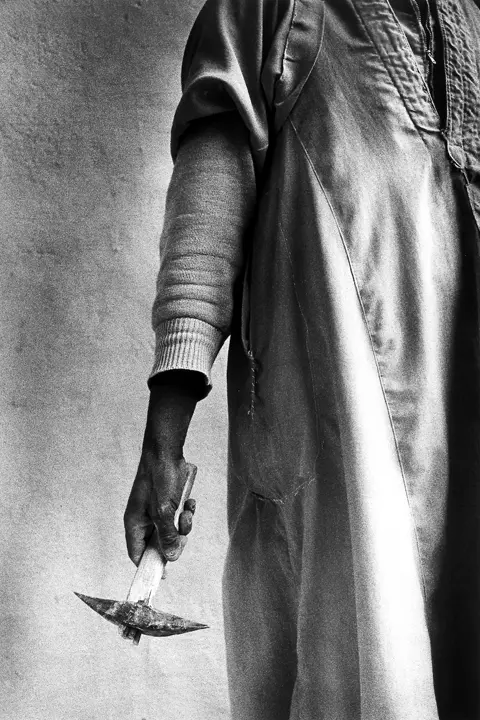 man holding a hammer b&w