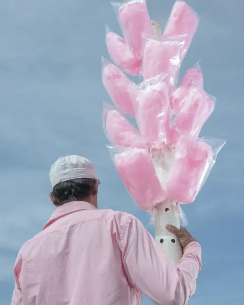 A man in a pink shirt with pink candyfloss