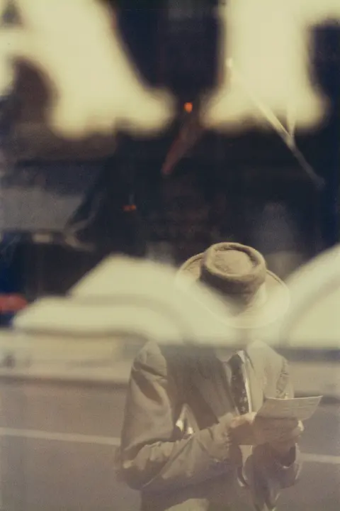Mann mit Hut und Buch mit Spiegelung, Saul Leiter