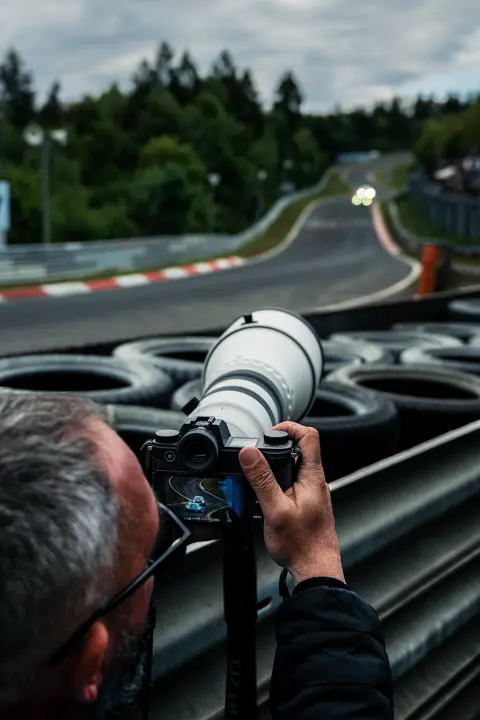 Callo Albanese using a Leica SL3-P with a super-telephoto lens trackside, capturing high-speed motorsport action.