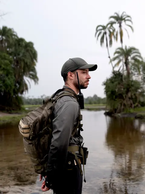 Mathias Depardon standing beside a river in a tropical ecosystem, documenting conservation work and exploration in a remote natural environment.