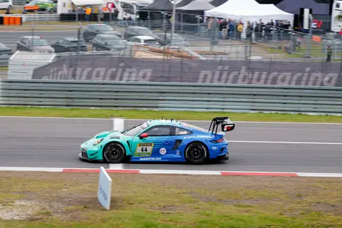 GT race car on a motorsport circuit, showcasing aerodynamic design and professional racing performance.