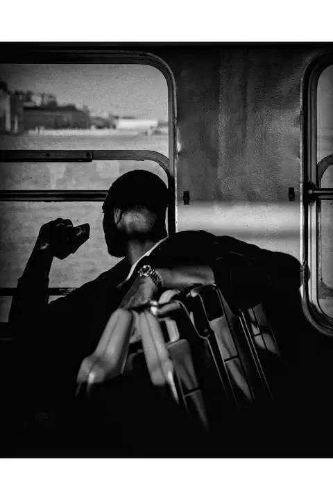 Portrait d'un homme assis dans un train, regardant par la fenêtre