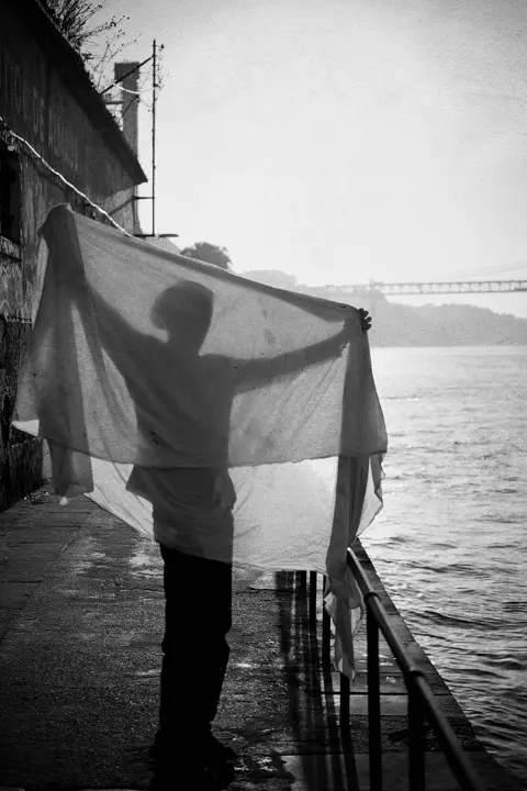 Ombre d'une personne pliant un filet de pêche