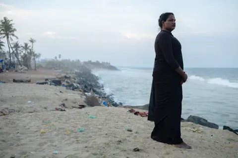 Femme au bord de la mer regardant l'horizon