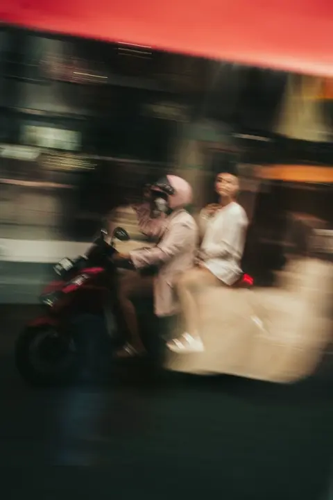 Two people are riding on a motorcycle