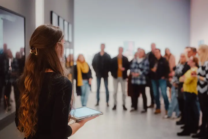 A woman stands in front of a group of people